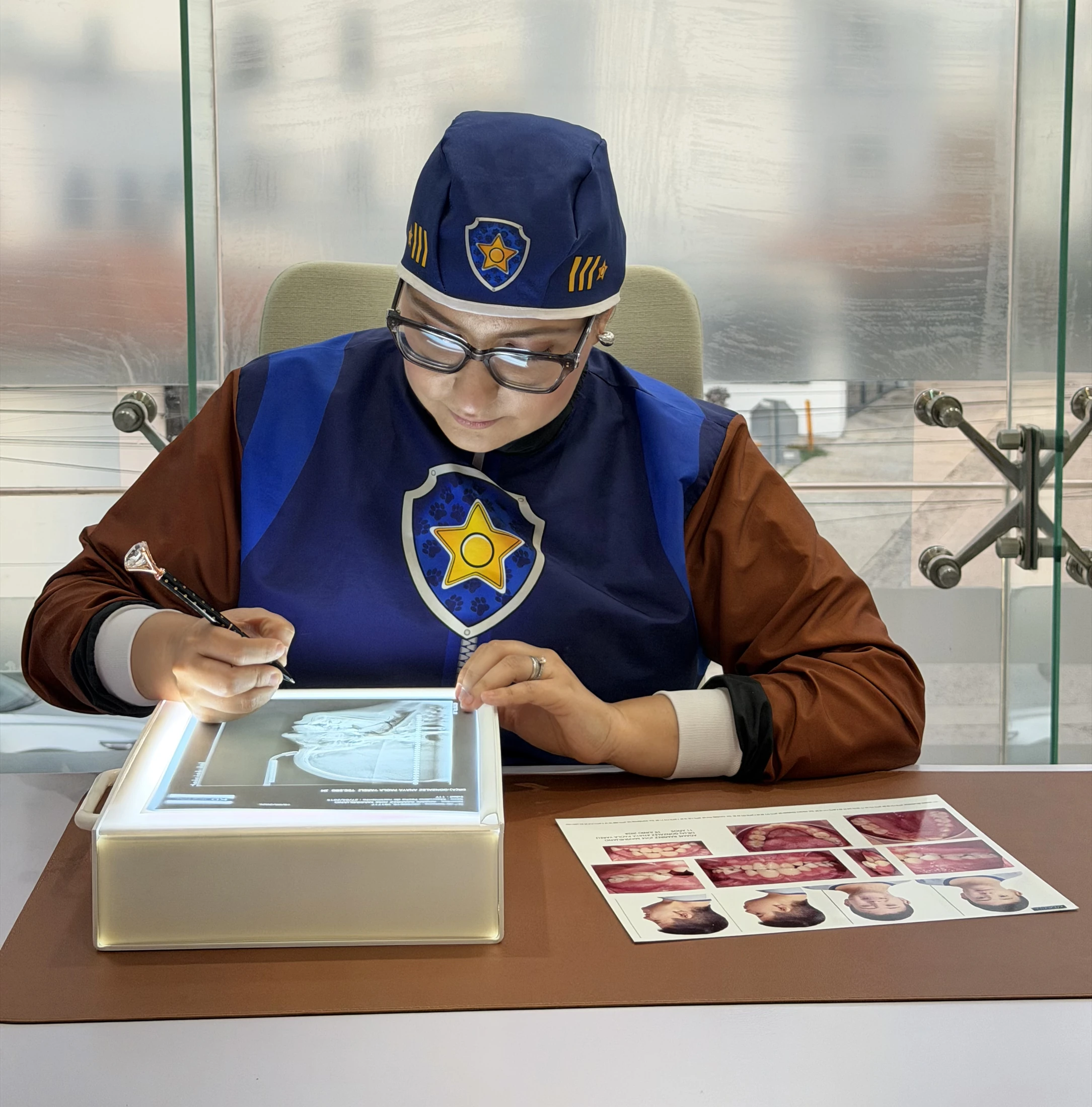 Odontopediatra revisando radiografías con vestuario de Chase